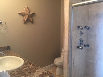 Master bath with shower with body sprays and Gulf view, granite countertops