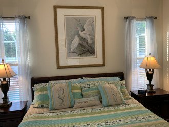 King bed with upscale linens, two nightstands and weather station/clock