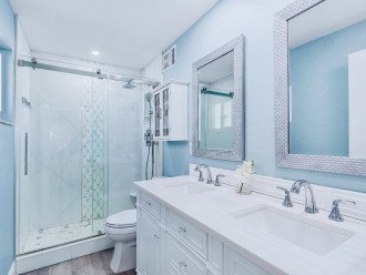 Primary ensuite bathroom w/double sink vanity and walk-in custom tile shower.
