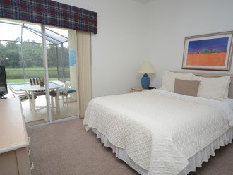 Queen bedroom with TV and view of pool