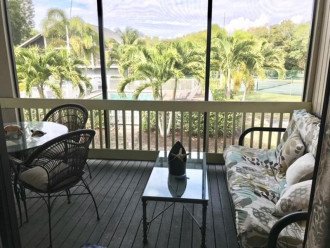 Futon and table with 4 chairs on the right side of the screened in front lanai