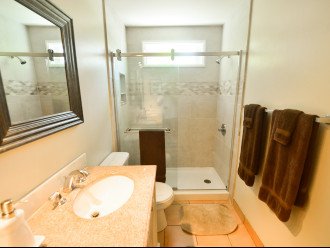 Contemporary walk-in shower in large bathroom with double vanity.