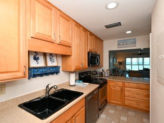 Modern, renovated kitchen, opens to living/dining area and window/door overlooking the bay and boat docks