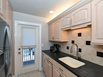 Modern, renovated, fully equipped kitchen with composite counters, tile back splash...