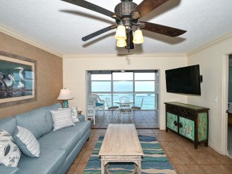 Spacious living room with view out to Lanai, the beach and azure waters of the Gulf of Mexico...large HDTV, stereo, and more...