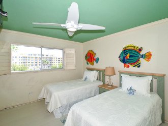 3rd bedroom with two twin-size beds, HDTV, large window overlooking the bay and boat docks