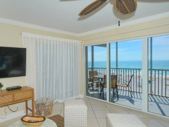 Large living room with floor-to-ceiling sliders opening to screened in Lanai - spectacular views of world famous Crescent Beach and the Gulf of Mexico. Large flat panel HDTV