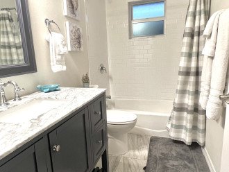 Third bath, located in hall, has tiled shower/tub combo
