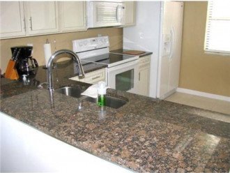 Kitchen fully equipped with granite countertops with small table
